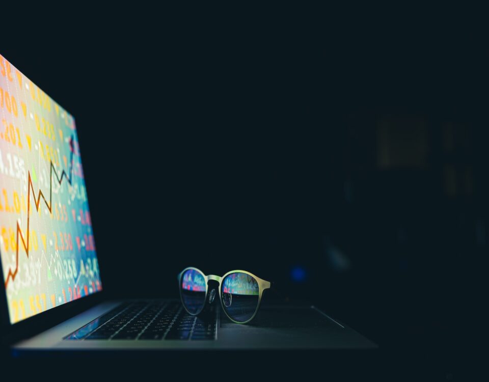 Stock market graph, financial data on an electronic board on a laptop screen.