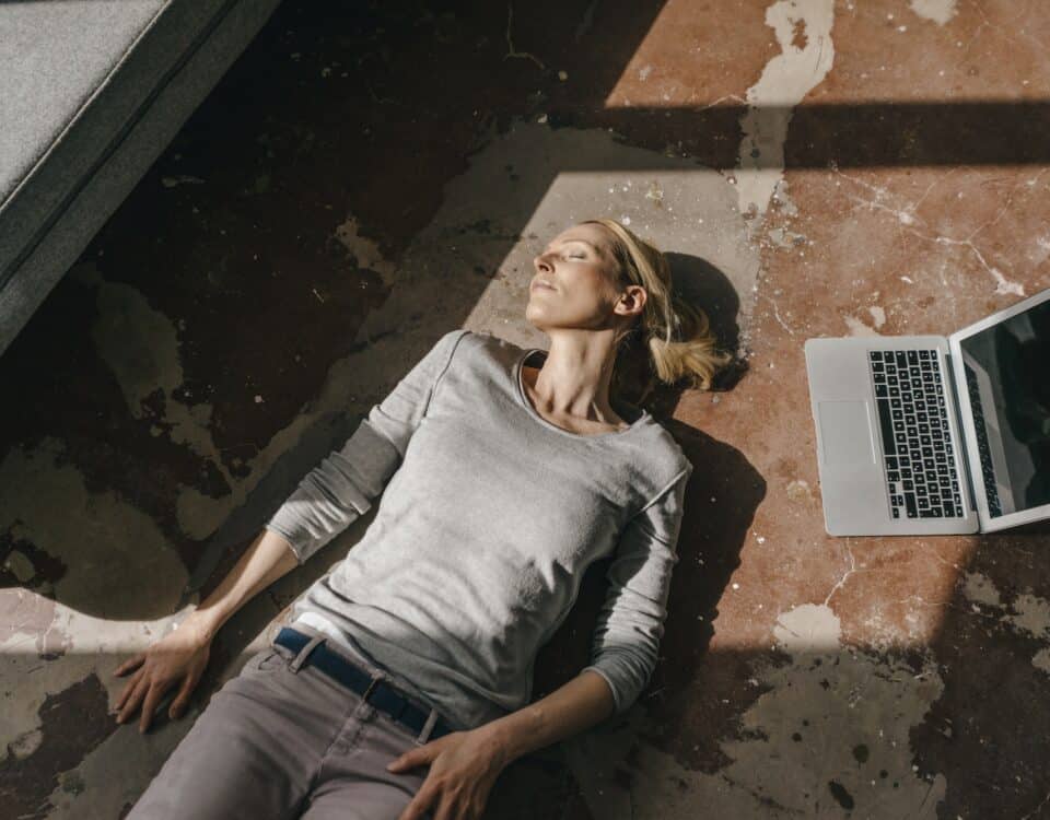 Woman sleeping on the floor next to laptop