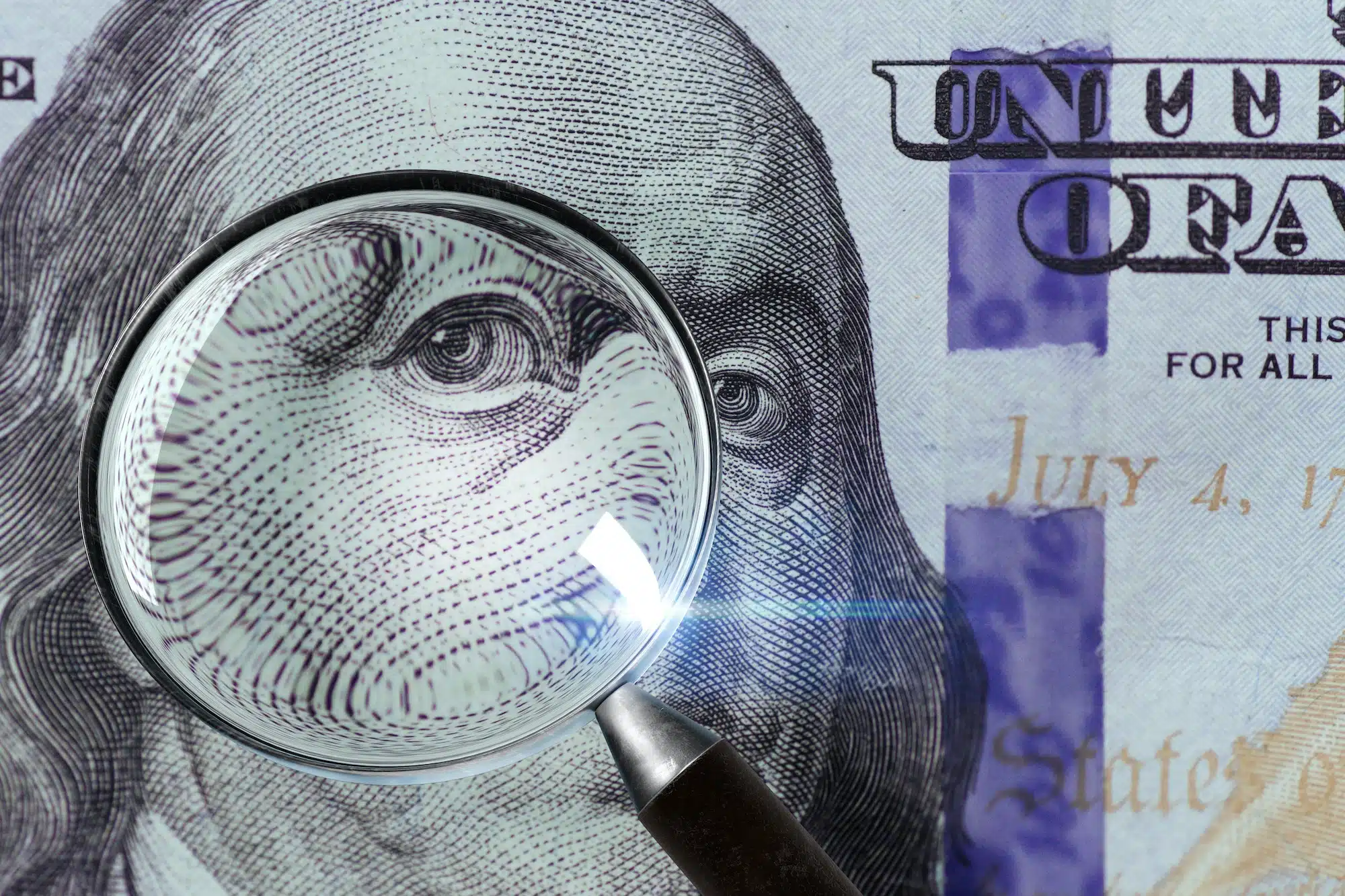 100 US Dollar under magnifying glass